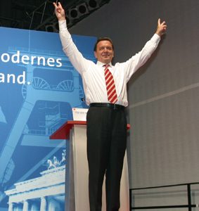 Gerhard Schröder mit erhobenen Armen und Victoryzeichen während der Wahlkampfveranstaltung in Dortmund am 20. 09. 02