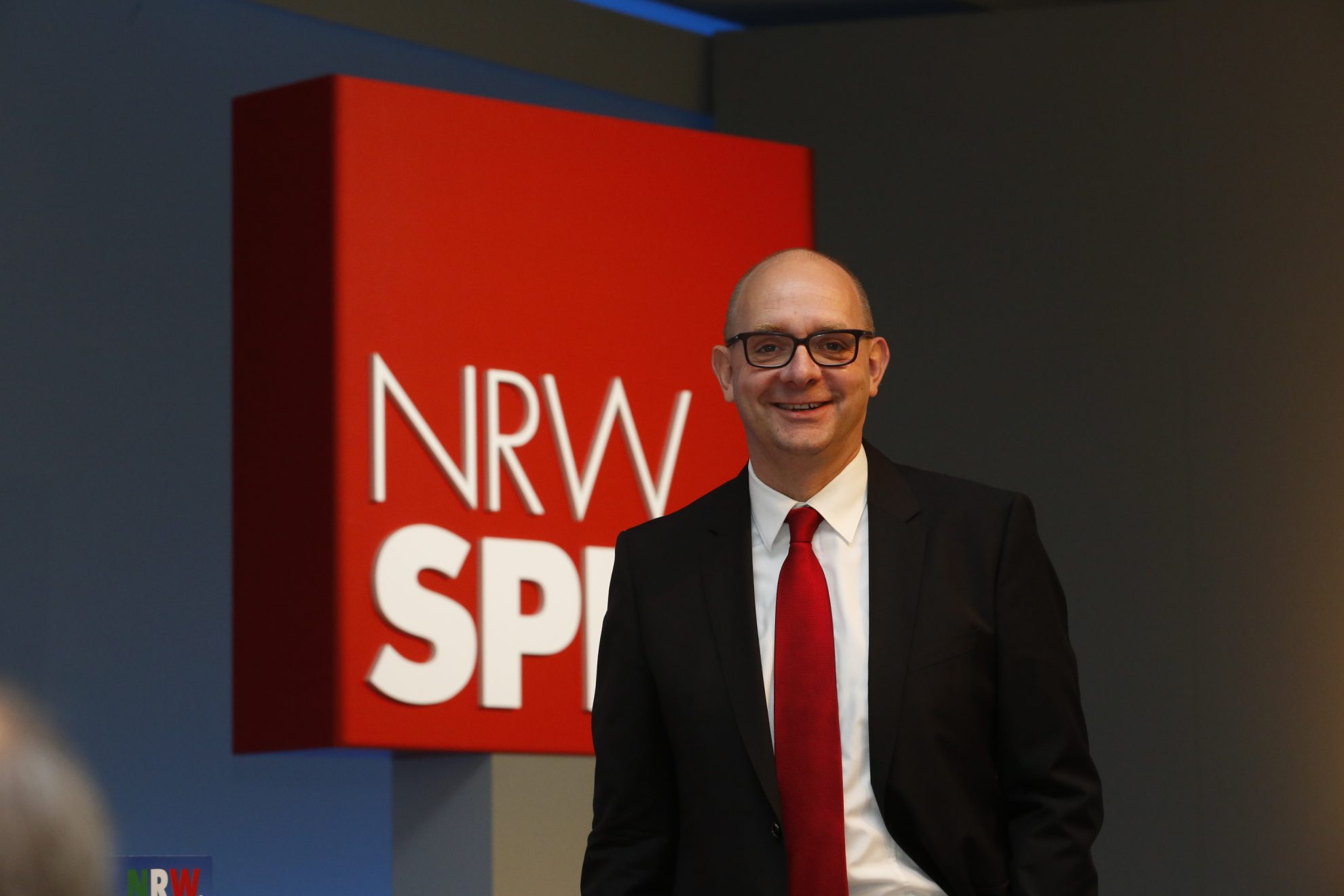 Andre Stinka vor dem Logo der NRWSPD