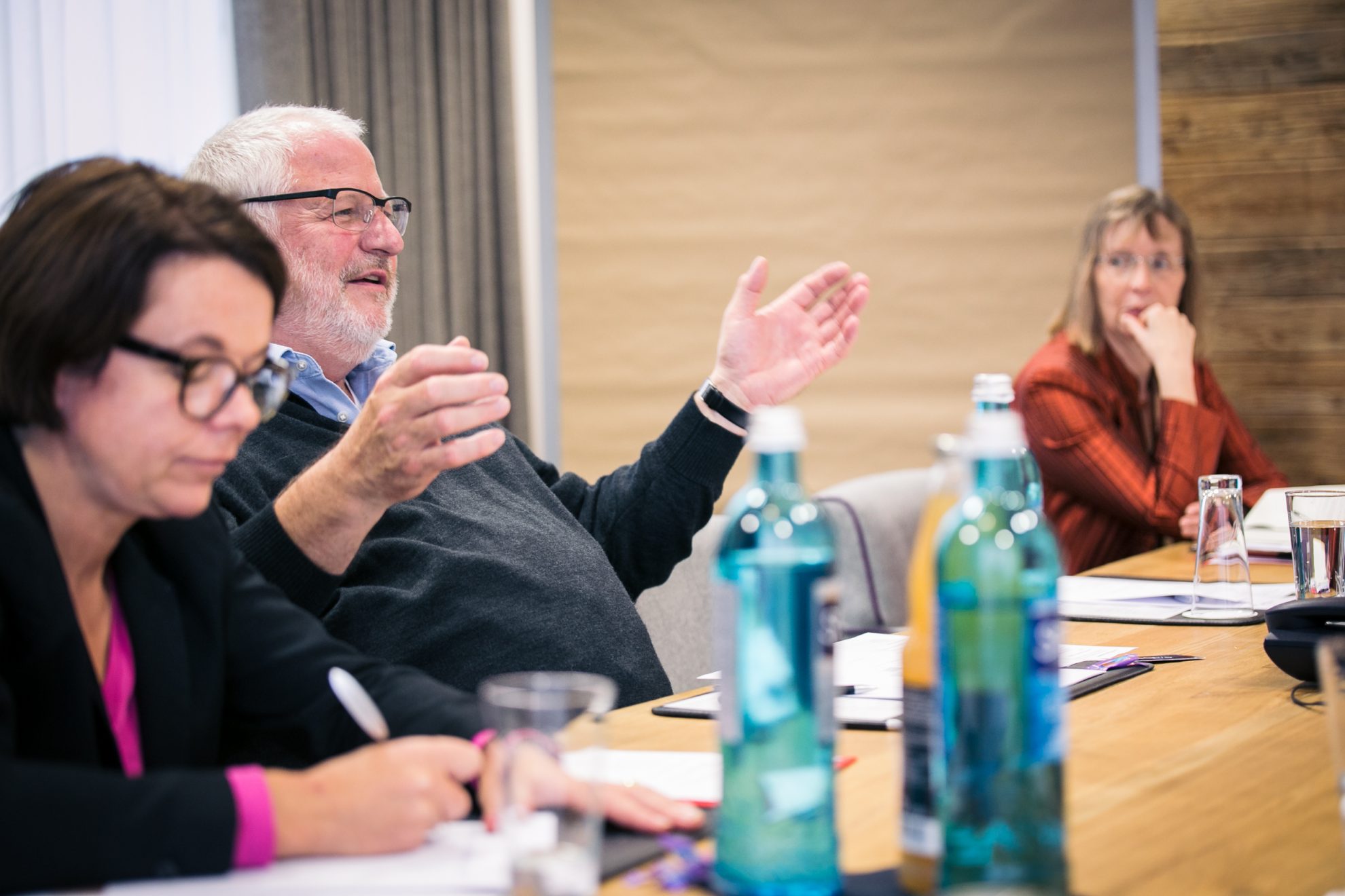 Mann spricht bei der Klausurtagung. Nadja Lüders schreibt im Vordergrund mit