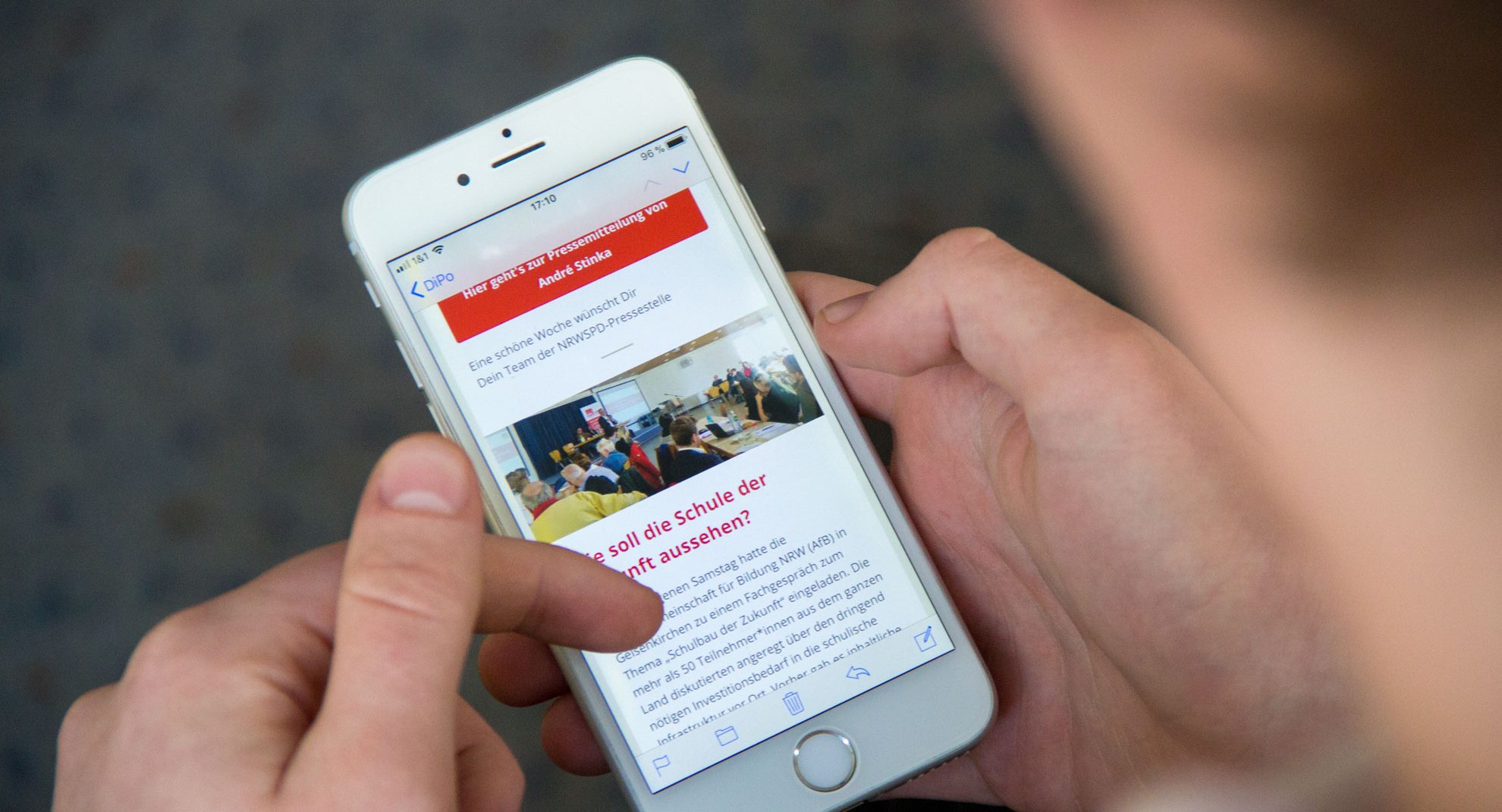 Ein Mann hält ein Handy und ist auf der Website der NRWSPD