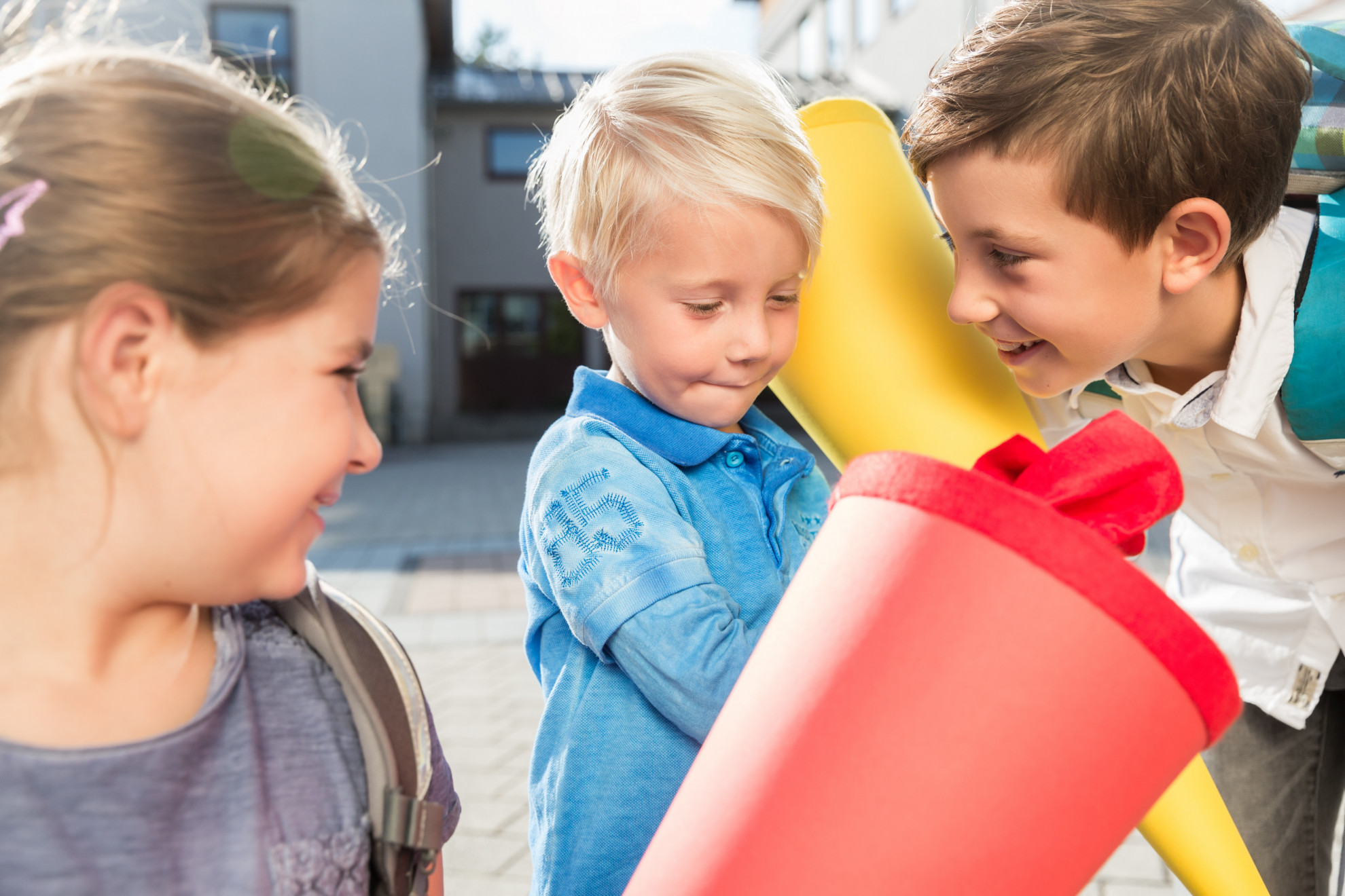 Foto: Kinder mit bunten Schultüten stehen vor einem Gebäude