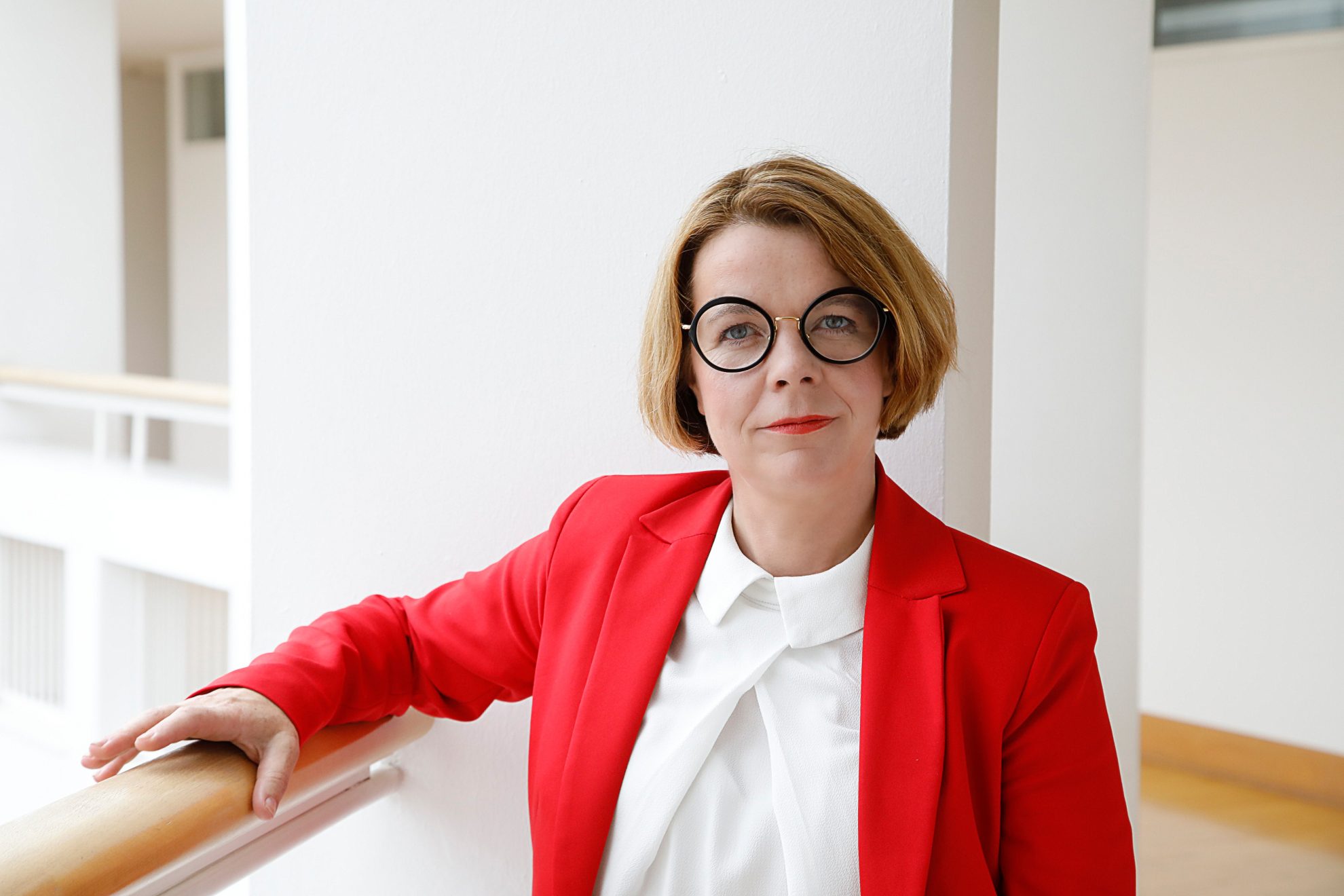 Porträtfoto von Anja Lüders. Ein Arm ist auf einem Geländer.