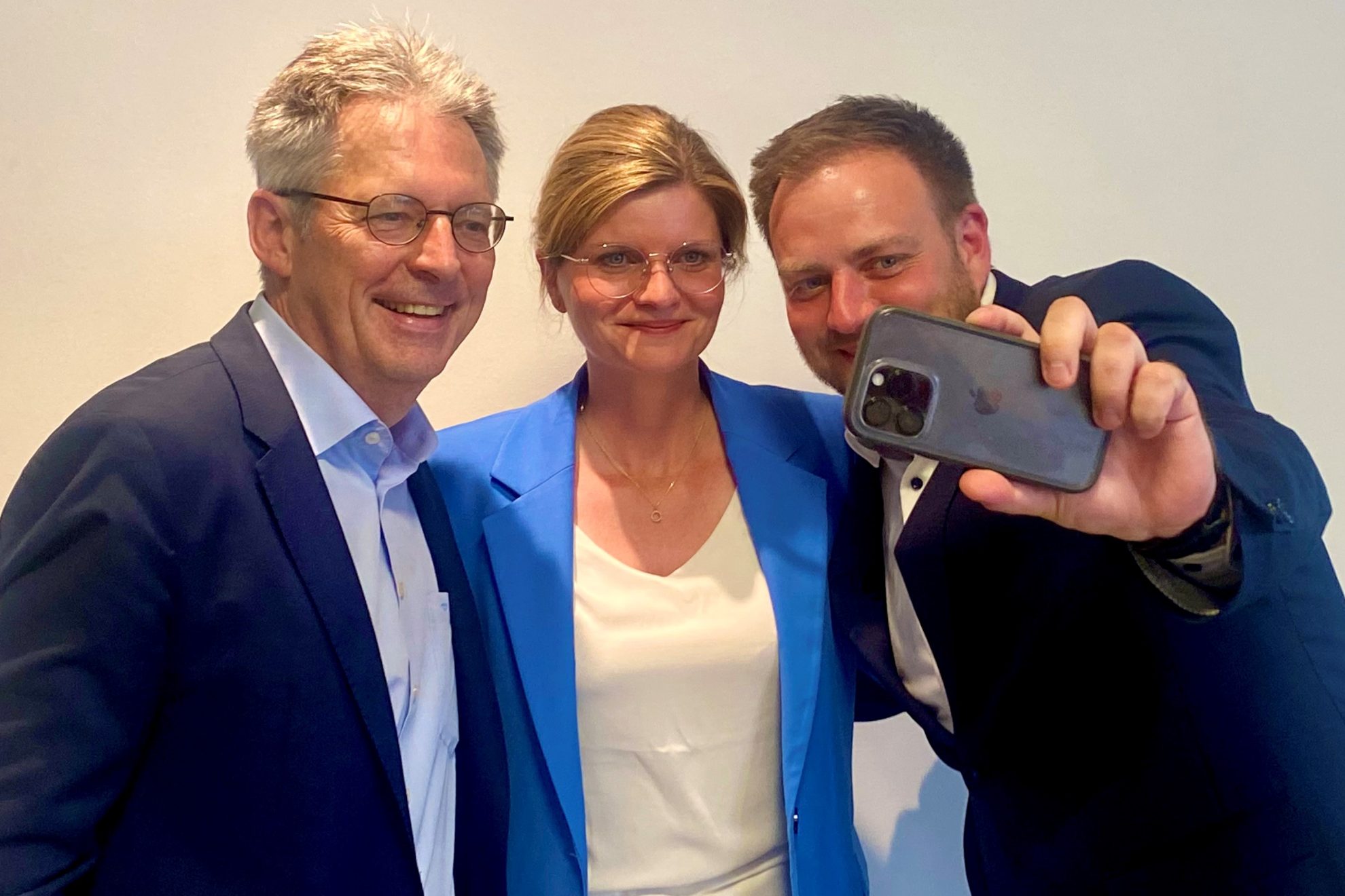 Auf diesem Foto sind Achim Post, Sarah Philipp und Frederick Cordes zu sehen. Frederick Cordes hat ein Handy in der Hand, um ein Selfi von den dreien zu machen.