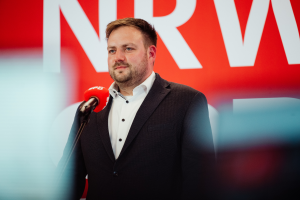 Frederick Cordes steht vor einem Mikrofon